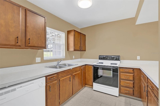 kitchen with white appliances, sink, and light tile patterned floors