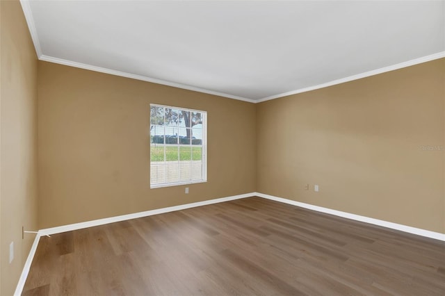 empty room with wood-type flooring and crown molding