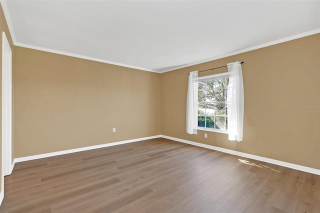 spare room featuring wood-type flooring and crown molding