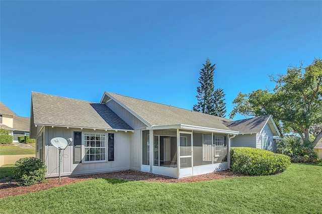 rear view of property featuring a sunroom and a yard