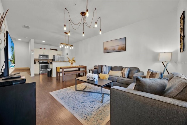 living room with dark hardwood / wood-style flooring and a notable chandelier