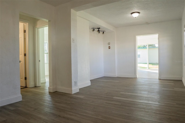 spare room with dark hardwood / wood-style flooring and a textured ceiling