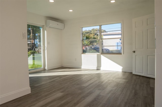 unfurnished room featuring a wall mounted AC and dark hardwood / wood-style flooring