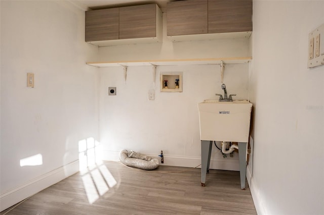 laundry area with electric dryer hookup, cabinets, hookup for a washing machine, and light hardwood / wood-style flooring