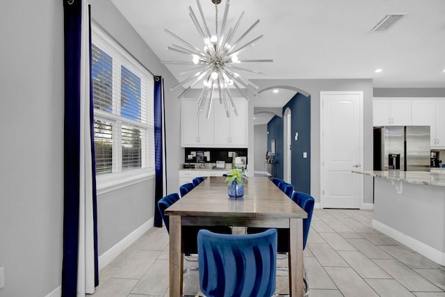 tiled dining area featuring a chandelier