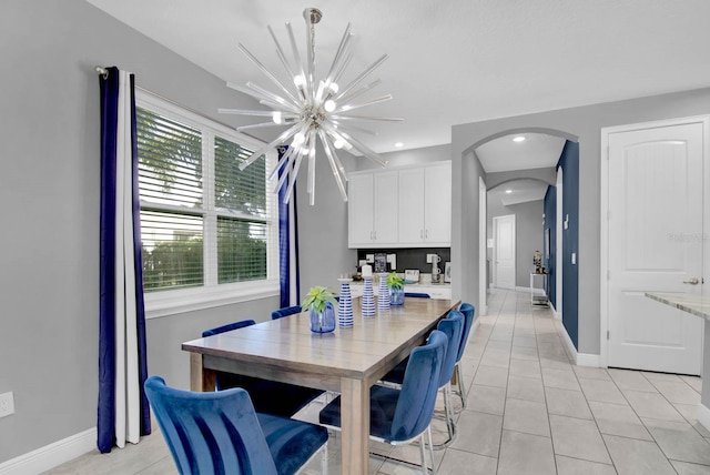 dining room featuring a notable chandelier and light tile patterned flooring