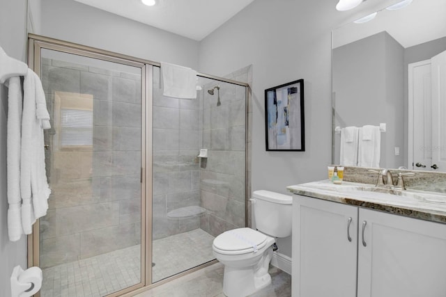 bathroom featuring vanity, toilet, and a shower with door