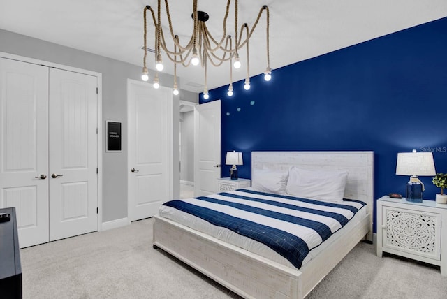 bedroom with light colored carpet, a closet, and a notable chandelier