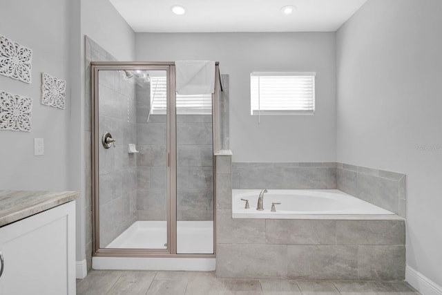 bathroom with vanity and independent shower and bath