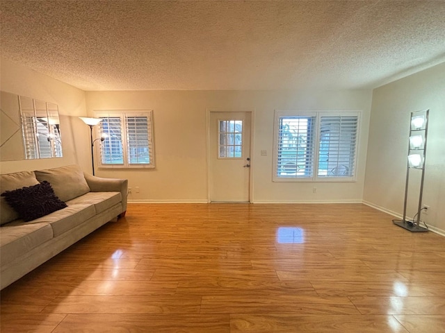 unfurnished living room with a textured ceiling and light wood-type flooring