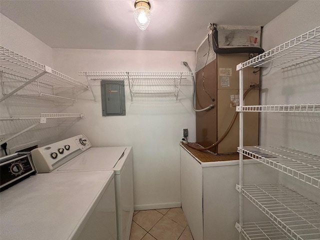 laundry area with electric panel, washer and clothes dryer, and light tile patterned floors