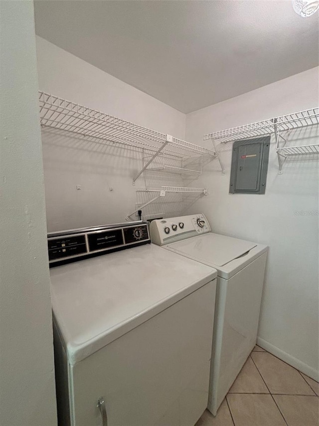 laundry room with light tile patterned floors, independent washer and dryer, and electric panel