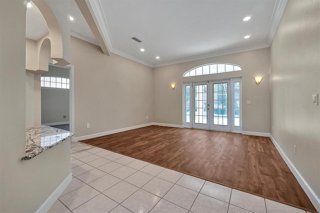 spare room featuring french doors, light hardwood / wood-style floors, and ornamental molding