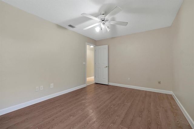 spare room featuring hardwood / wood-style floors and ceiling fan