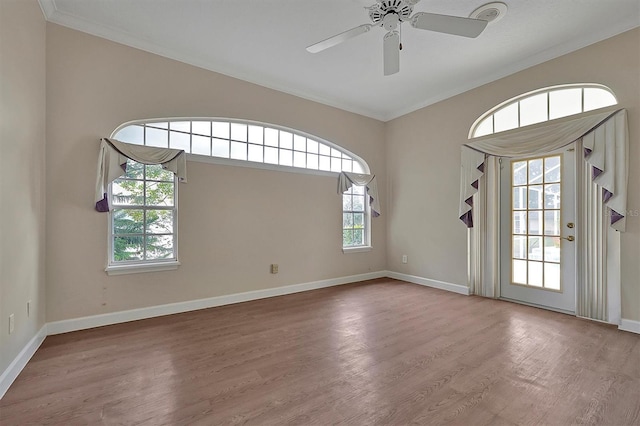 empty room featuring hardwood / wood-style floors, plenty of natural light, and ornamental molding