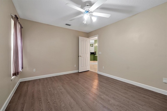 spare room with dark wood-type flooring and ceiling fan