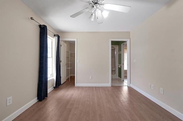 unfurnished room with ceiling fan, a textured ceiling, and light hardwood / wood-style flooring