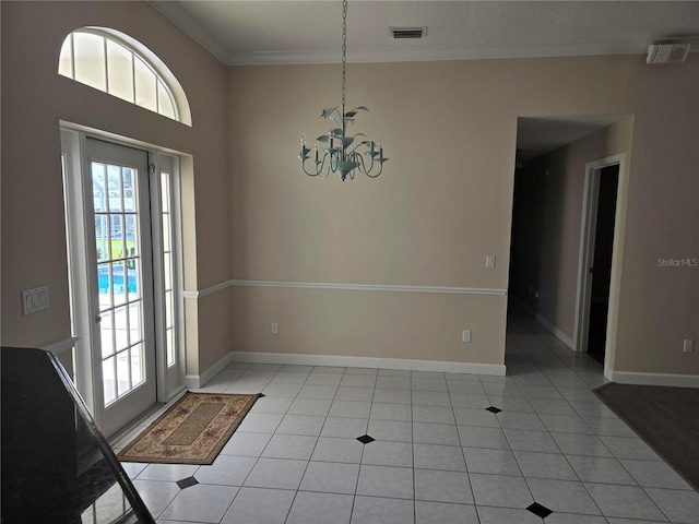 tiled entrance foyer with crown molding and a chandelier