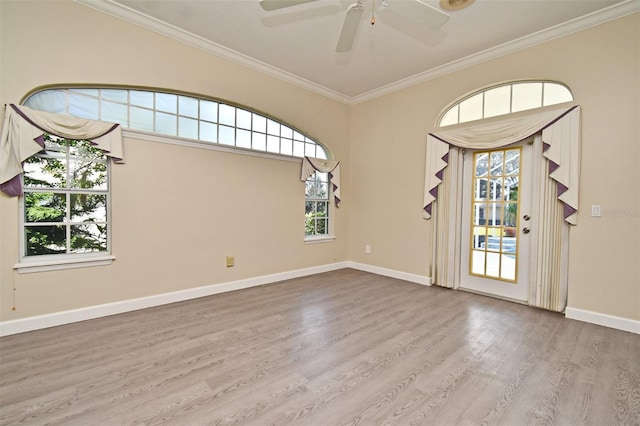 spare room featuring crown molding, ceiling fan, a healthy amount of sunlight, and light wood-type flooring