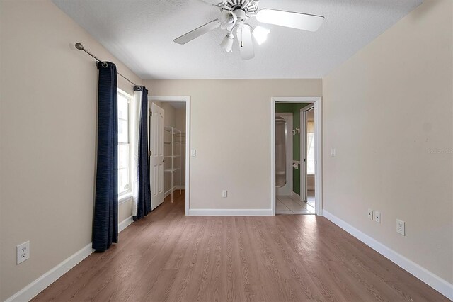 349 Plantation Club Dr, Debary, FL 32713 - unfurnished bedroom featuring multiple windows, a spacious closet, light wood-style flooring, and a textured ceiling