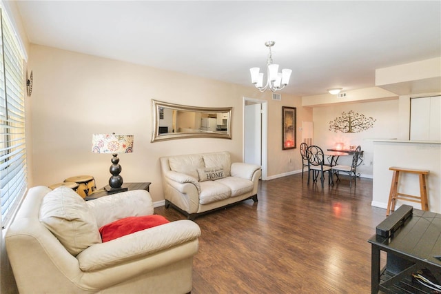 living room with a healthy amount of sunlight, dark wood-type flooring, and a chandelier