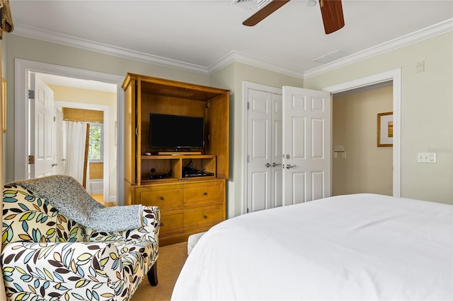 carpeted bedroom with ceiling fan, crown molding, and a closet