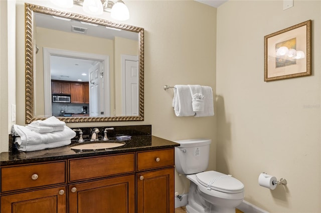 bathroom featuring vanity and toilet