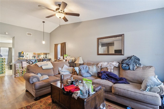 living room featuring hardwood / wood-style flooring, ceiling fan, and vaulted ceiling