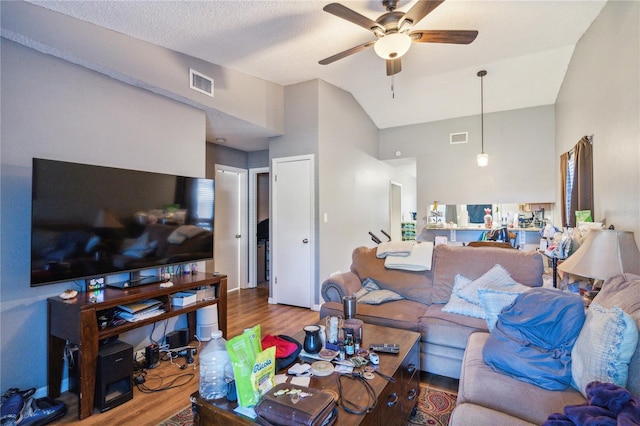 living room with hardwood / wood-style flooring, ceiling fan, a textured ceiling, and high vaulted ceiling