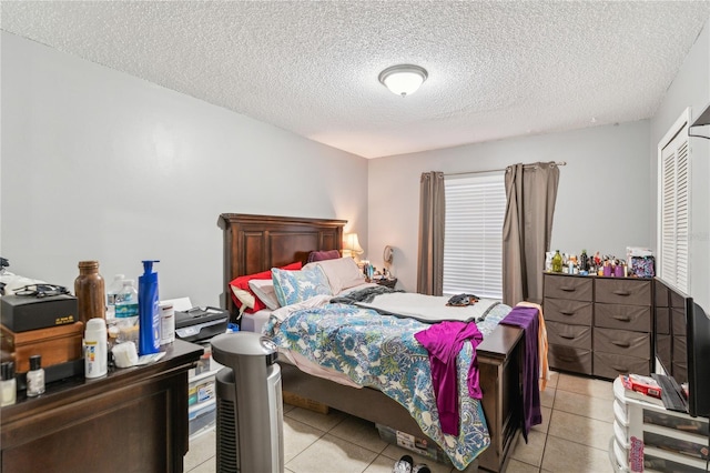 bedroom with a textured ceiling and light tile patterned flooring