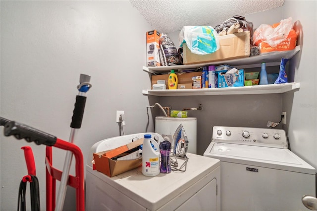 laundry room featuring water heater, a textured ceiling, and independent washer and dryer