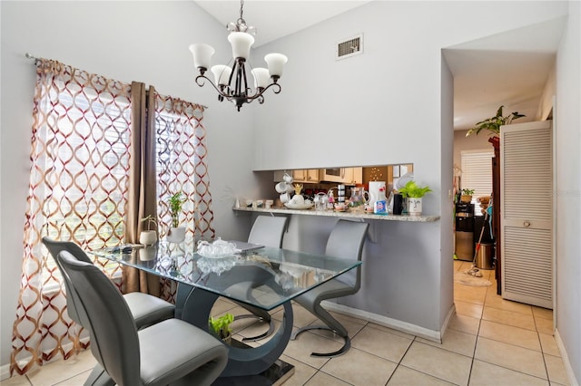 tiled dining area featuring an inviting chandelier