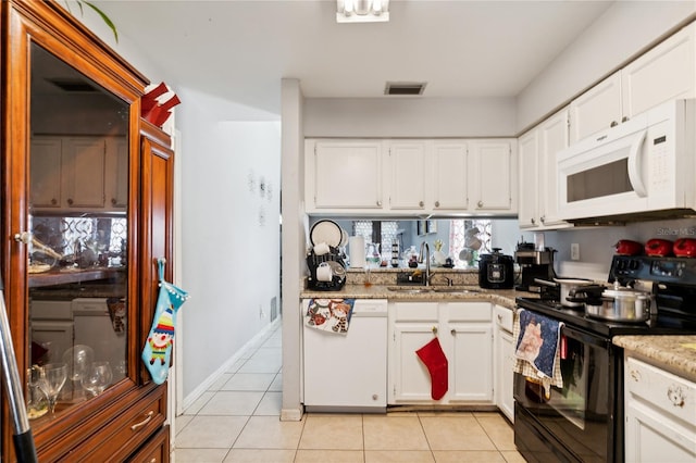 kitchen featuring white cabinets, white appliances, light tile patterned flooring, and sink