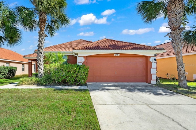 mediterranean / spanish house with a front lawn and a garage