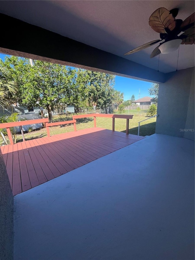 wooden deck featuring ceiling fan and a yard