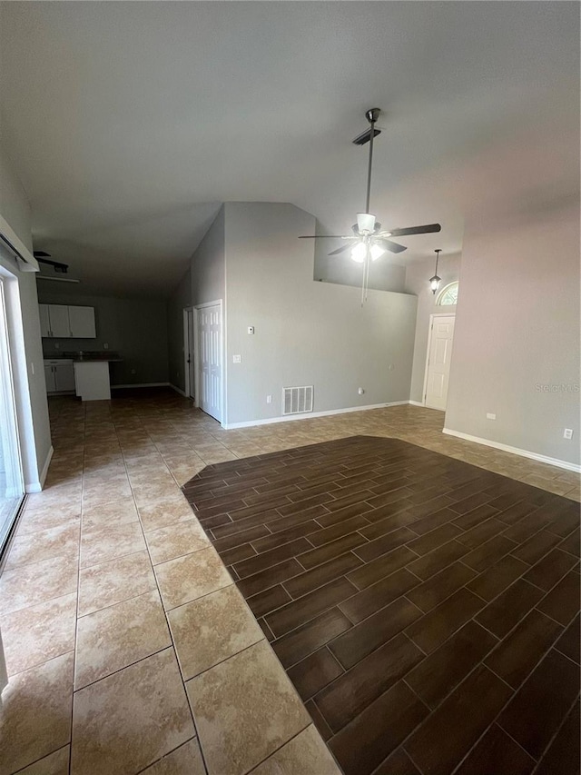 unfurnished living room featuring ceiling fan, dark hardwood / wood-style flooring, and vaulted ceiling