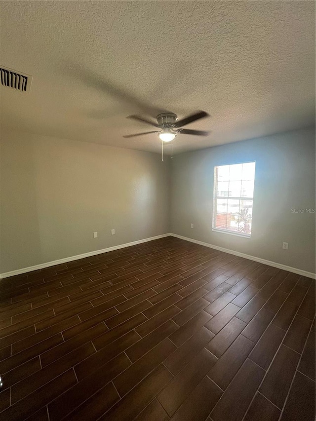 empty room with a textured ceiling, ceiling fan, and dark wood-type flooring