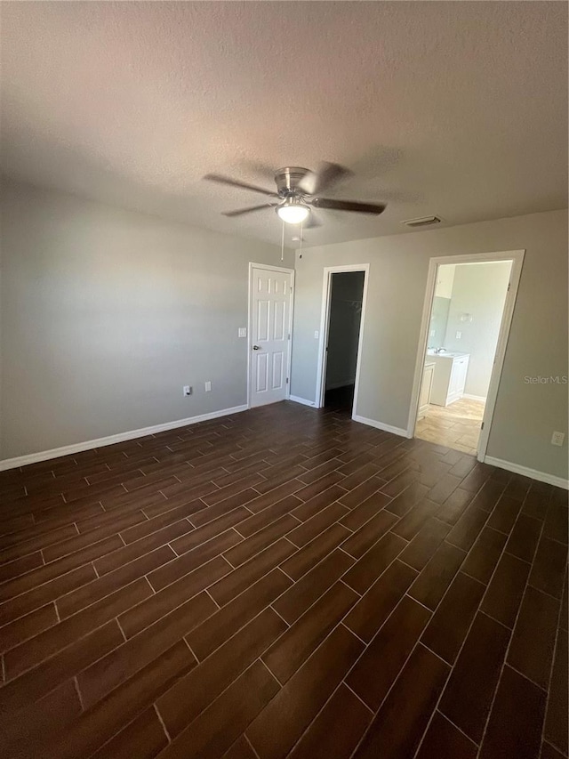 spare room featuring a textured ceiling, dark hardwood / wood-style flooring, and ceiling fan