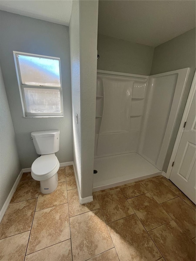 bathroom with tile patterned floors, toilet, and walk in shower