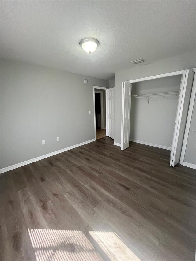 6336 Florida Cir, Apollo Beach, FL 33572 - unfurnished bedroom with dark wood-style flooring, a closet, and baseboards