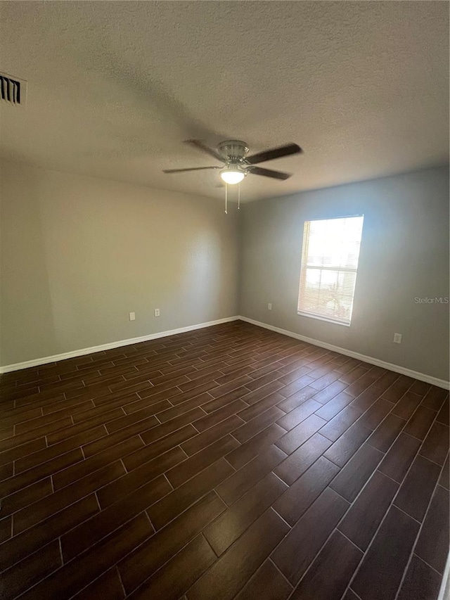 empty room with a textured ceiling, ceiling fan, and dark wood-type flooring