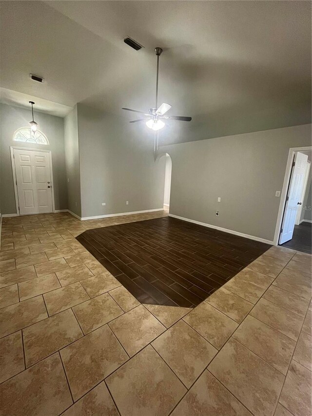 6336 Florida Cir, Apollo Beach, FL 33572 - unfurnished living room featuring ceiling fan, lofted ceiling, baseboards, tile patterned flooring, and arched walkways