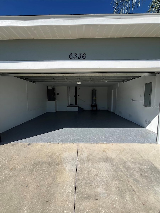 garage with strapped water heater and electric panel