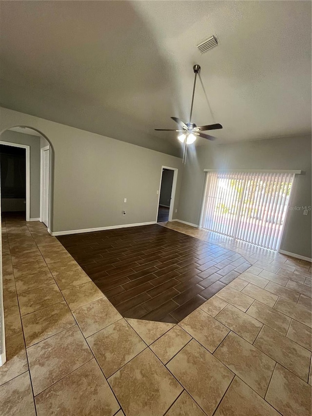 6336 Florida Cir, Apollo Beach, FL 33572 - unfurnished room featuring a ceiling fan, arched walkways, baseboards, a textured ceiling, and tile patterned flooring