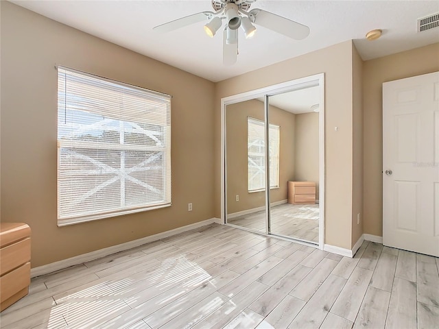 unfurnished bedroom featuring light hardwood / wood-style floors, a closet, and ceiling fan