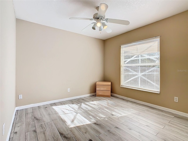 empty room with ceiling fan and light hardwood / wood-style floors