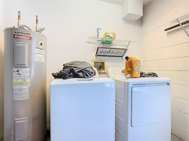 laundry area featuring washer and dryer, electric water heater, and wooden walls