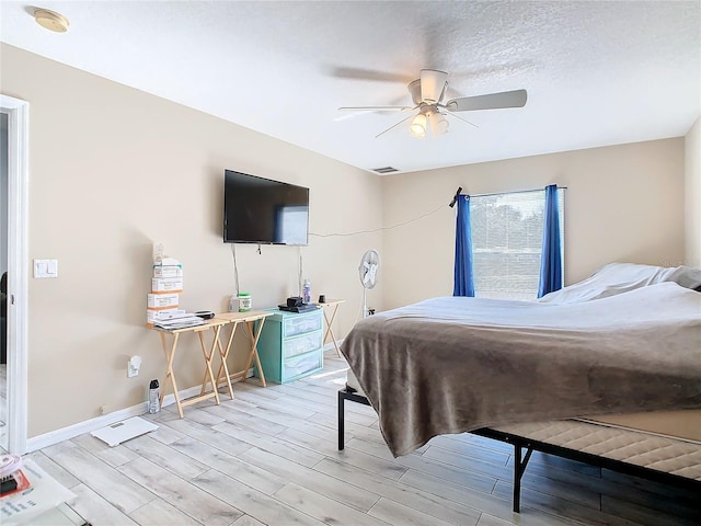 bedroom featuring a textured ceiling, light hardwood / wood-style floors, and ceiling fan