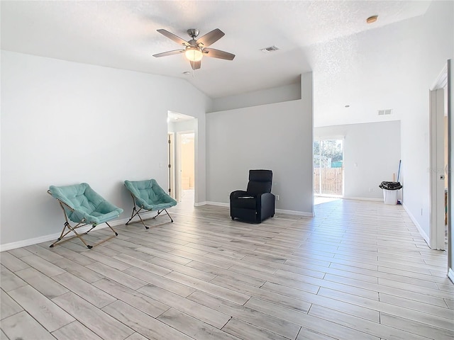 unfurnished room with a textured ceiling, ceiling fan, lofted ceiling, and light wood-type flooring