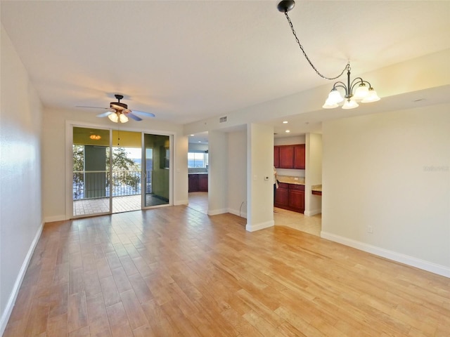 unfurnished living room featuring light hardwood / wood-style floors and ceiling fan with notable chandelier